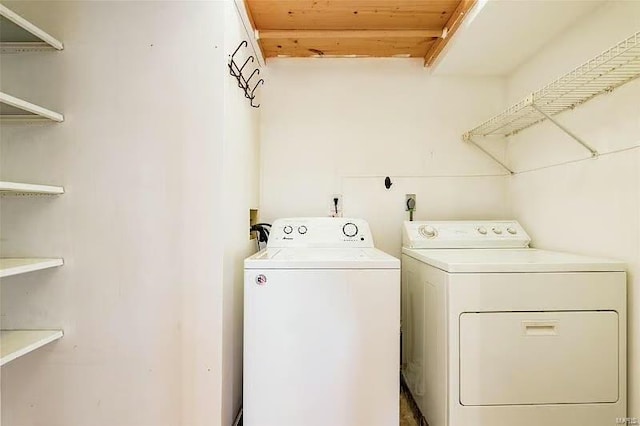 clothes washing area featuring laundry area, wooden ceiling, and separate washer and dryer