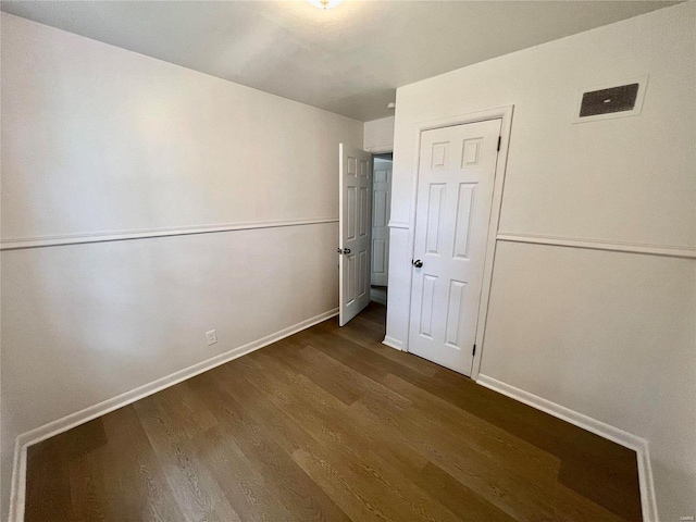 unfurnished bedroom with visible vents, baseboards, and wood finished floors