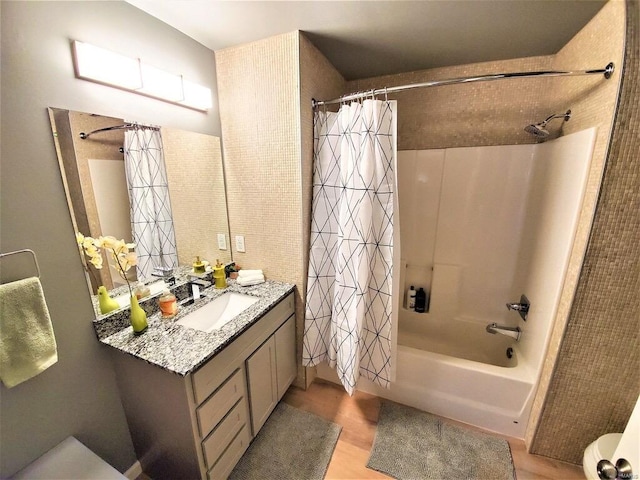 bathroom featuring toilet, shower / bathtub combination with curtain, and vanity