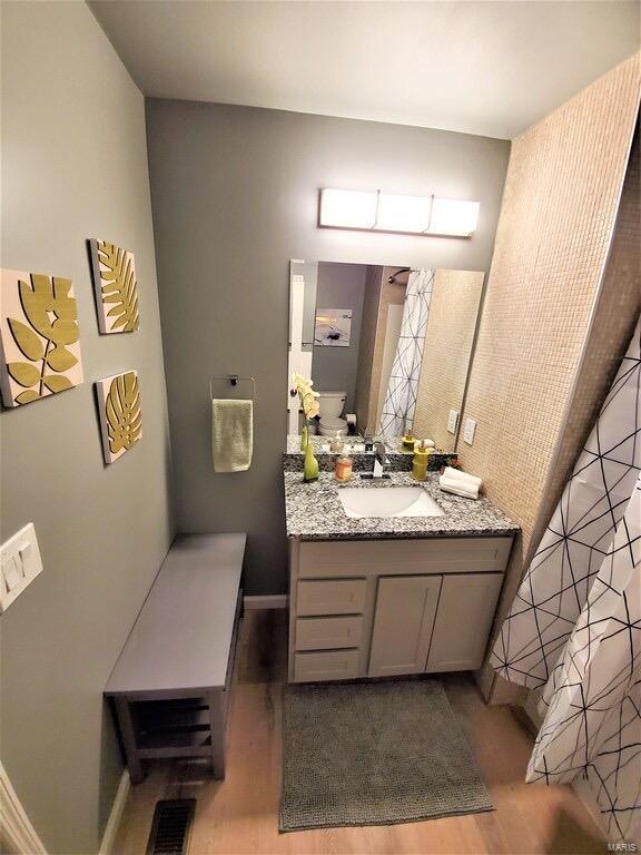 full bathroom with visible vents, wood finished floors, and vanity