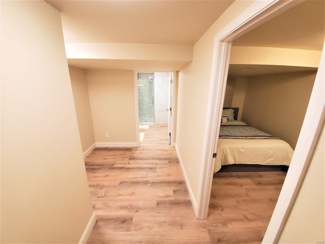 corridor featuring wood finished floors and baseboards