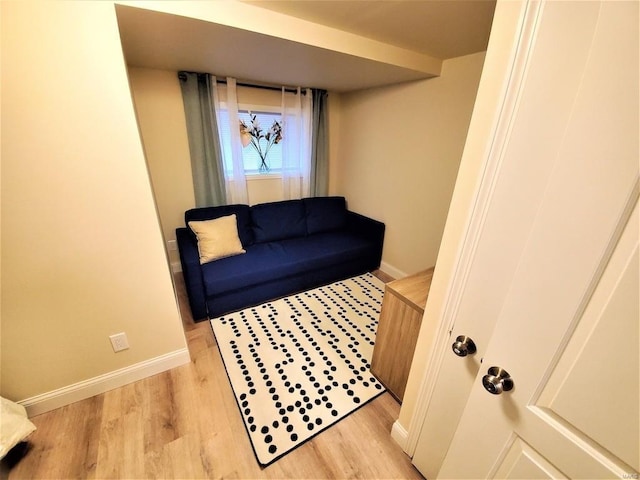 living area with light wood-type flooring and baseboards