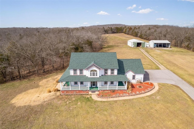 exterior space with a front lawn, an outbuilding, a porch, and driveway