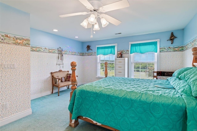 bedroom featuring a ceiling fan, visible vents, carpet floors, baseboards, and wallpapered walls