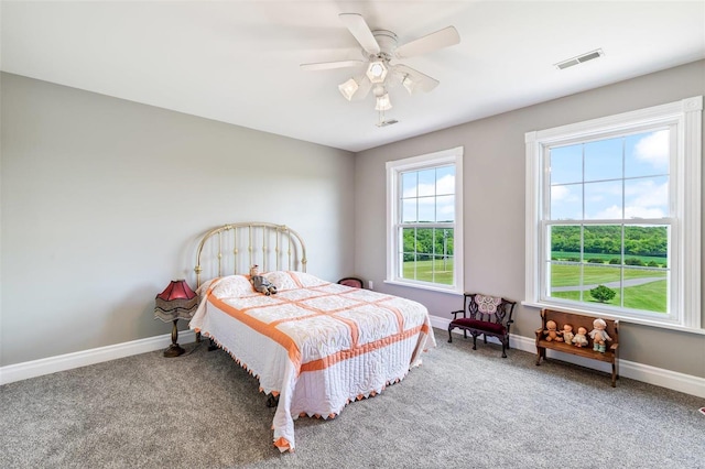 carpeted bedroom featuring visible vents, baseboards, and a ceiling fan