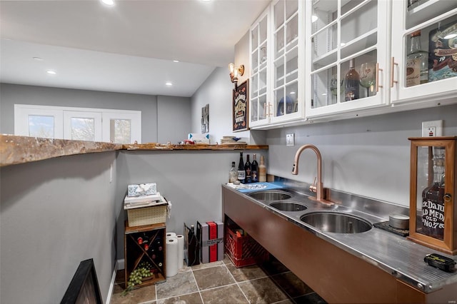 kitchen featuring recessed lighting, stainless steel countertops, glass insert cabinets, and white cabinets
