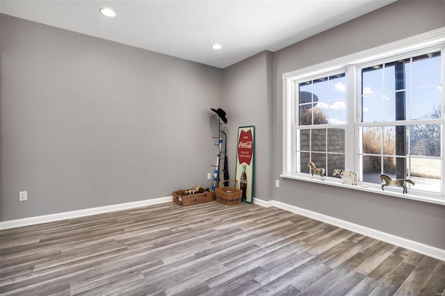 spare room with recessed lighting, wood finished floors, and baseboards