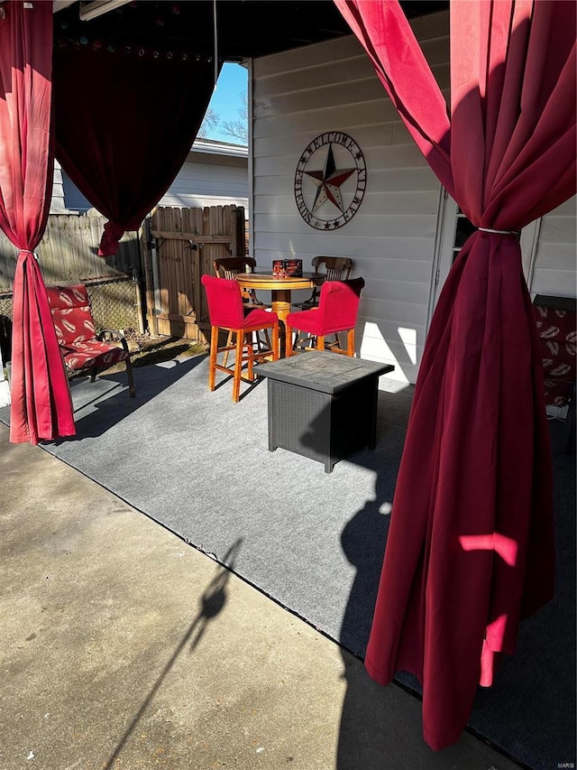 view of patio featuring outdoor dining area and fence