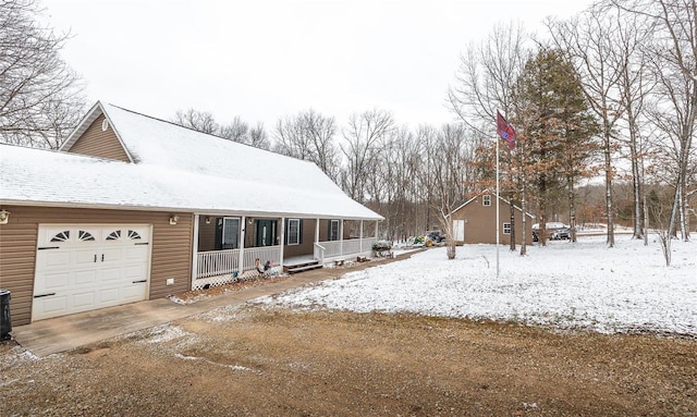 view of front of house with an attached garage, dirt driveway, and a porch