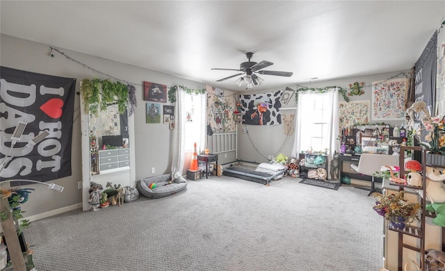 interior space with ceiling fan, carpet, and baseboards