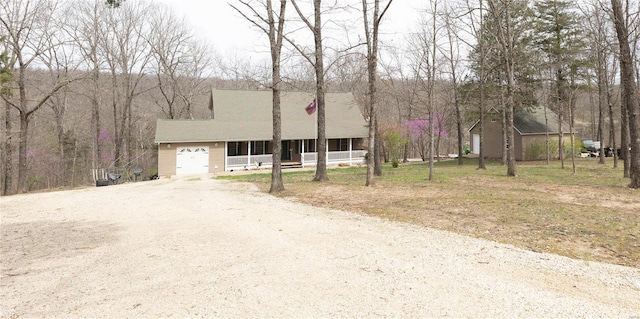 view of front of house featuring an attached garage, a porch, and driveway
