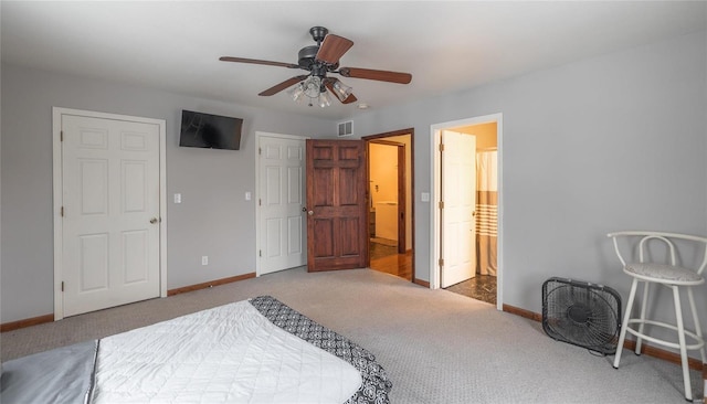 carpeted bedroom featuring ceiling fan, baseboards, visible vents, and connected bathroom