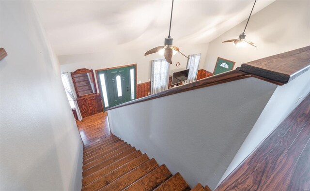 staircase with wood finished floors and ceiling fan