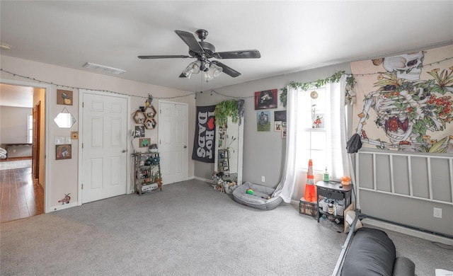 interior space with visible vents, ceiling fan, and carpet