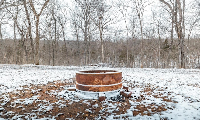 yard layered in snow with a wooded view