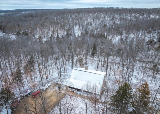 snowy aerial view featuring a wooded view