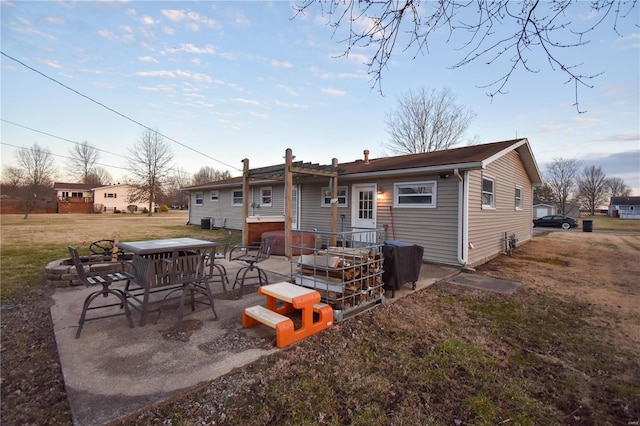 back of property featuring a patio area and a lawn