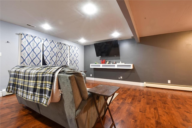 living area featuring visible vents, a baseboard radiator, baseboards, and wood finished floors