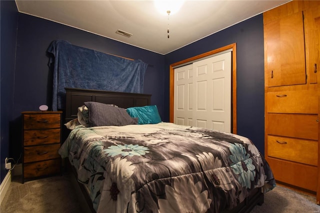 bedroom featuring visible vents, a closet, dark carpet, and baseboards