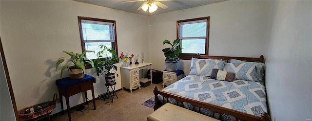 bedroom featuring a ceiling fan, multiple windows, and light colored carpet