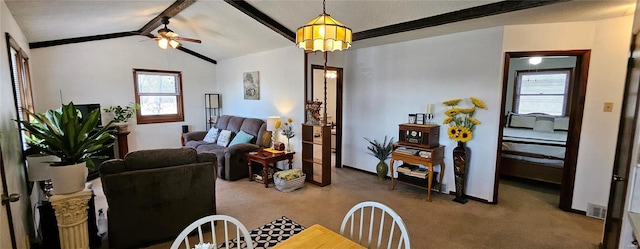 living room featuring visible vents, carpet floors, baseboards, ceiling fan, and vaulted ceiling with beams