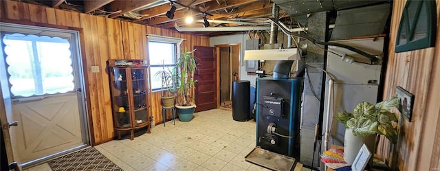 basement featuring light floors and wooden walls