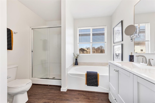 bathroom featuring toilet, a stall shower, plenty of natural light, and wood finished floors