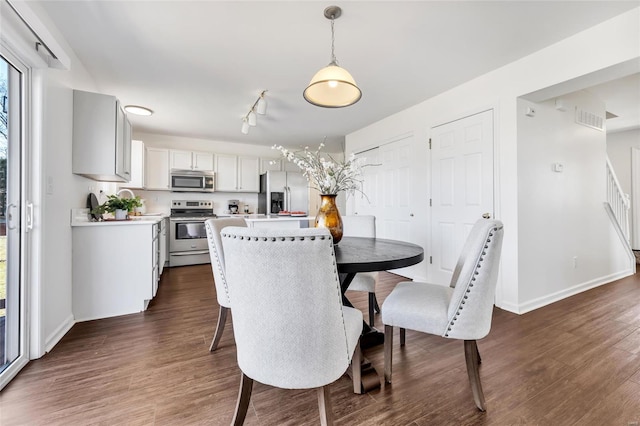 dining area featuring dark wood finished floors and baseboards