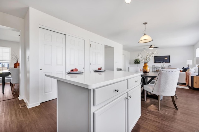 kitchen with dark wood-style floors, pendant lighting, open floor plan, and light countertops