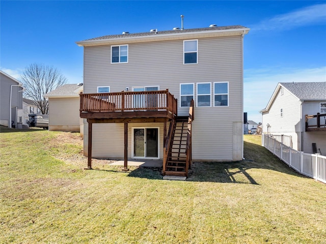 back of property featuring a deck, stairway, fence, and a lawn