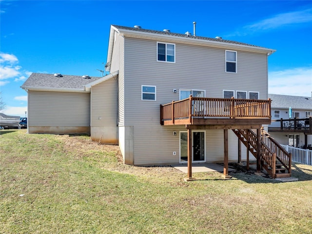 back of house featuring a patio area, a lawn, a wooden deck, and stairs