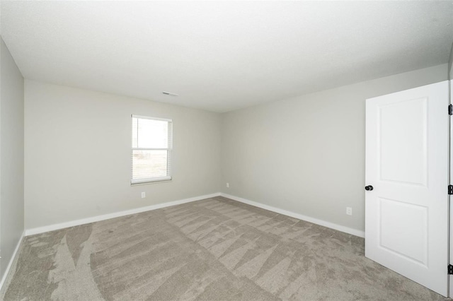 empty room featuring baseboards and carpet floors