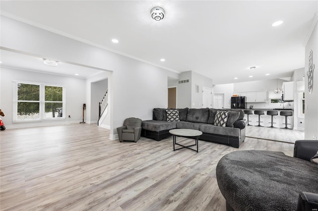 living area featuring light wood finished floors, baseboards, stairway, ornamental molding, and recessed lighting