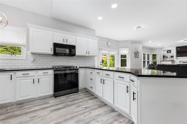 kitchen with dark countertops, a peninsula, stainless steel electric stove, light wood-type flooring, and black microwave