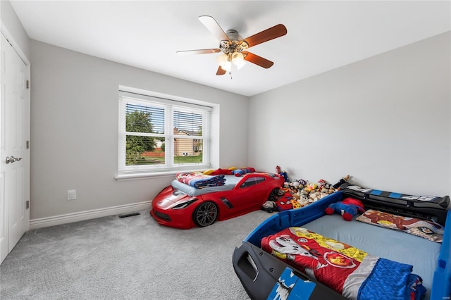 carpeted bedroom featuring ceiling fan, visible vents, and baseboards