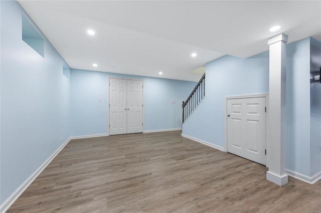 basement with stairway, recessed lighting, light wood-style flooring, and baseboards