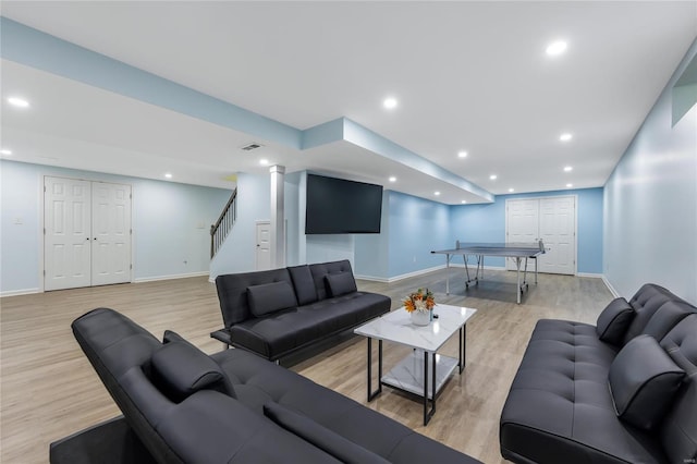 living area featuring baseboards, light wood-style floors, stairway, and recessed lighting