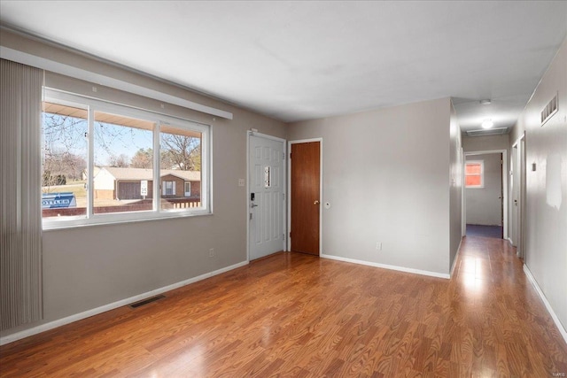 unfurnished room with visible vents, baseboards, and wood finished floors