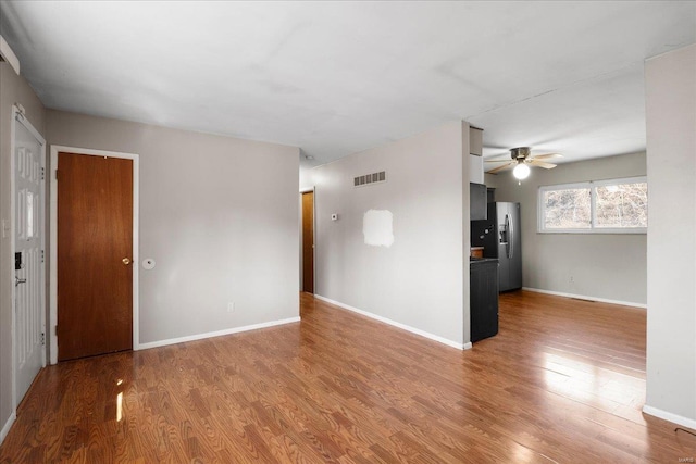 spare room with baseboards, visible vents, light wood finished floors, and ceiling fan