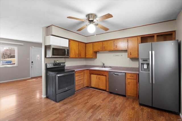 kitchen featuring a sink, ceiling fan, brown cabinetry, stainless steel appliances, and dark wood-style flooring