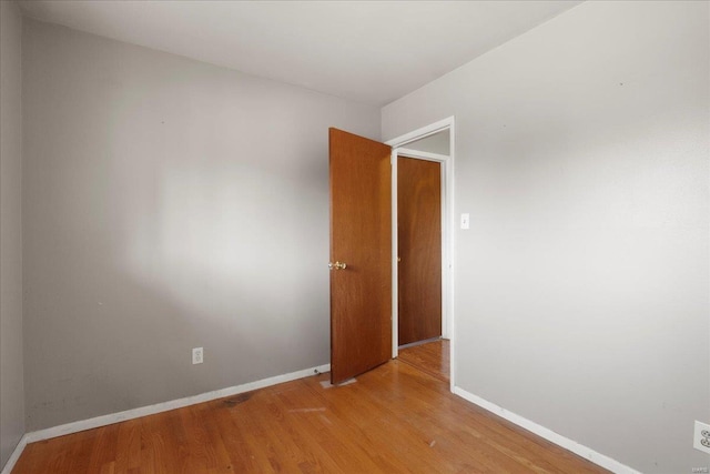 empty room featuring light wood-style flooring and baseboards