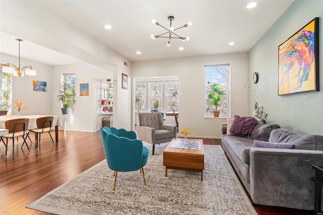 living area featuring baseboards, a chandelier, wood finished floors, and recessed lighting