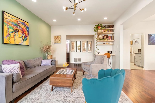 living area featuring recessed lighting, wood-type flooring, visible vents, and an inviting chandelier