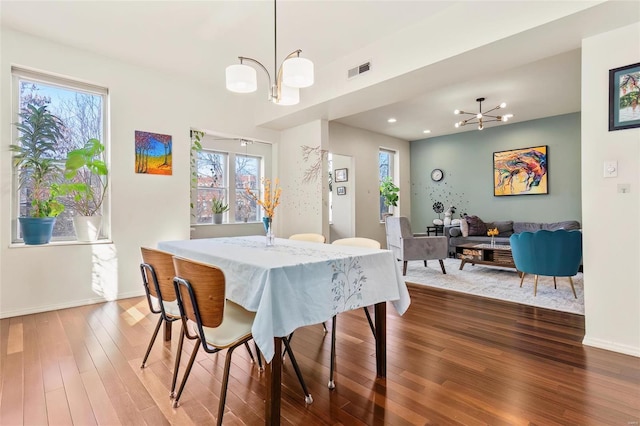 dining space with a notable chandelier, recessed lighting, visible vents, wood finished floors, and baseboards