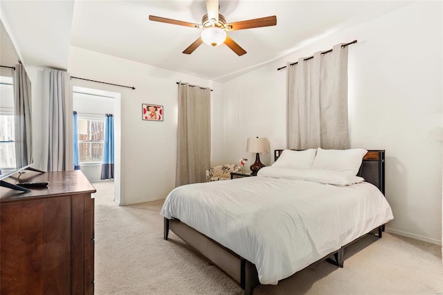 bedroom with baseboards, a ceiling fan, and light colored carpet