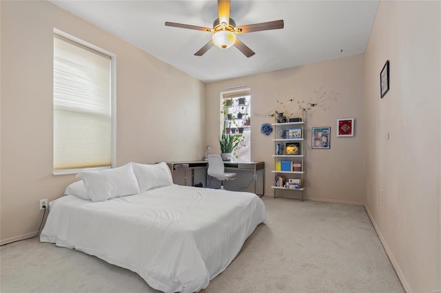 bedroom with baseboards, ceiling fan, and light colored carpet