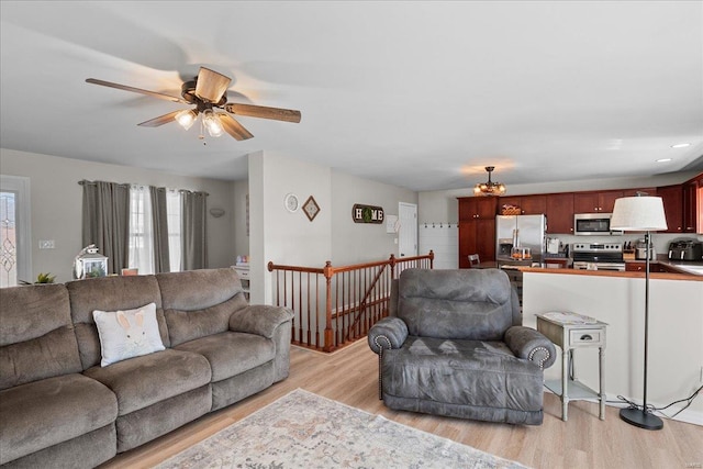 living area featuring ceiling fan and light wood finished floors