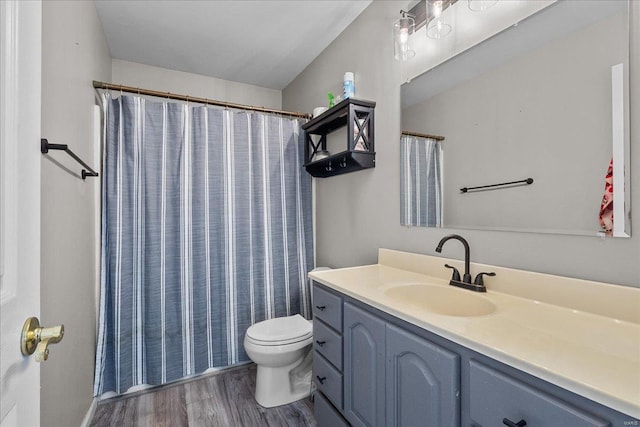 full bathroom with a shower with shower curtain, vanity, toilet, and wood finished floors