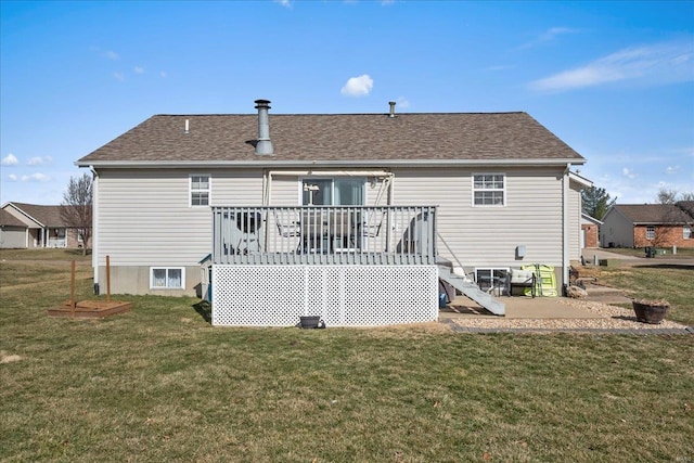 rear view of house featuring a shingled roof, a lawn, and a wooden deck