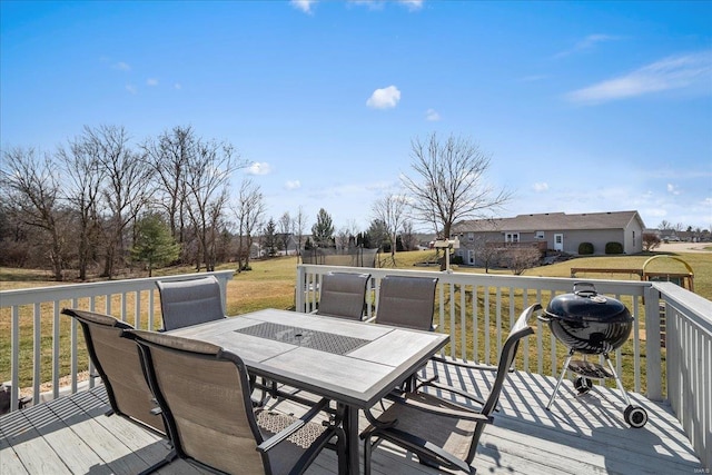 wooden deck with outdoor dining space and a lawn